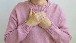 a woman holds her chest while experiencing respiratory depression