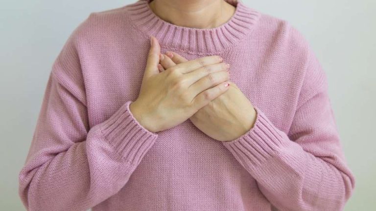a woman holds her chest while experiencing respiratory depression