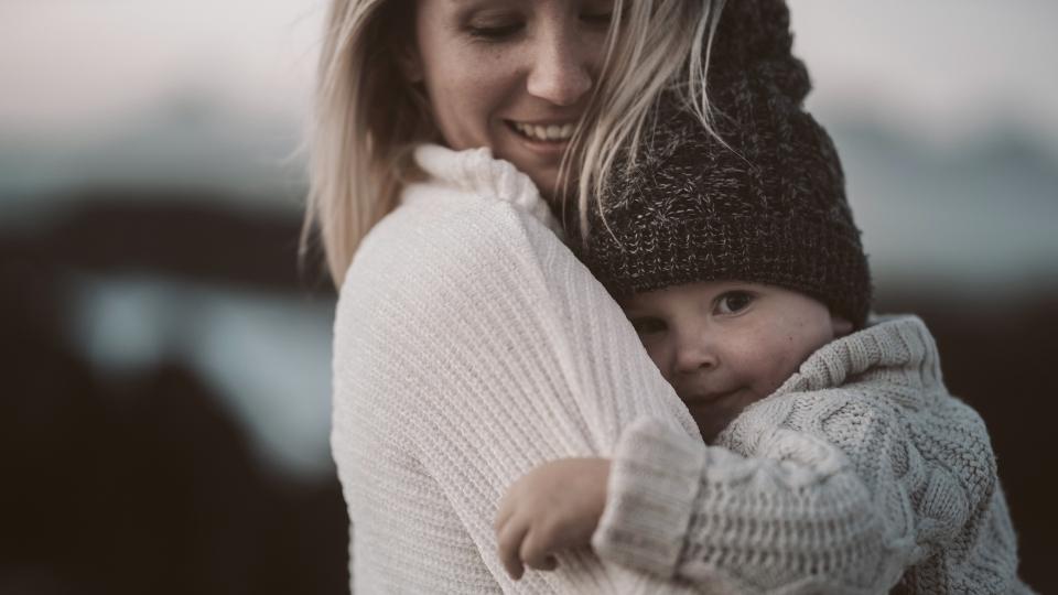 Is Addiction Hereditary a woman holds her child while thinking about family history of addiction.