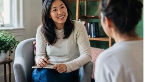 How To Prepare for Intensive Outpatient Treatment hero image of a woman in talking to a therapist.