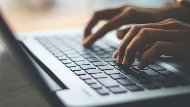 Is IOP Covered by Insurance hero image of a man looking up the answer on his computer.